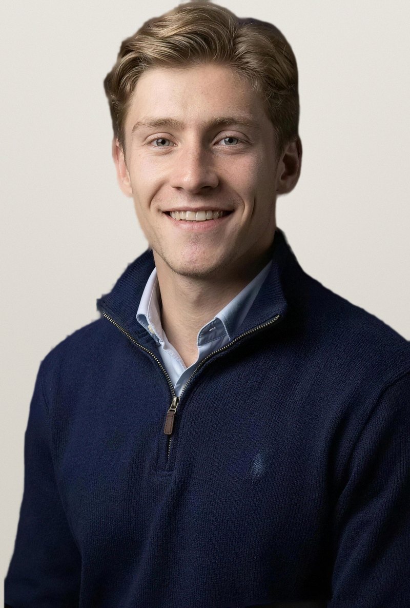 Portrait de Greg, en pull bleu marine sur une chemise bleu clair.